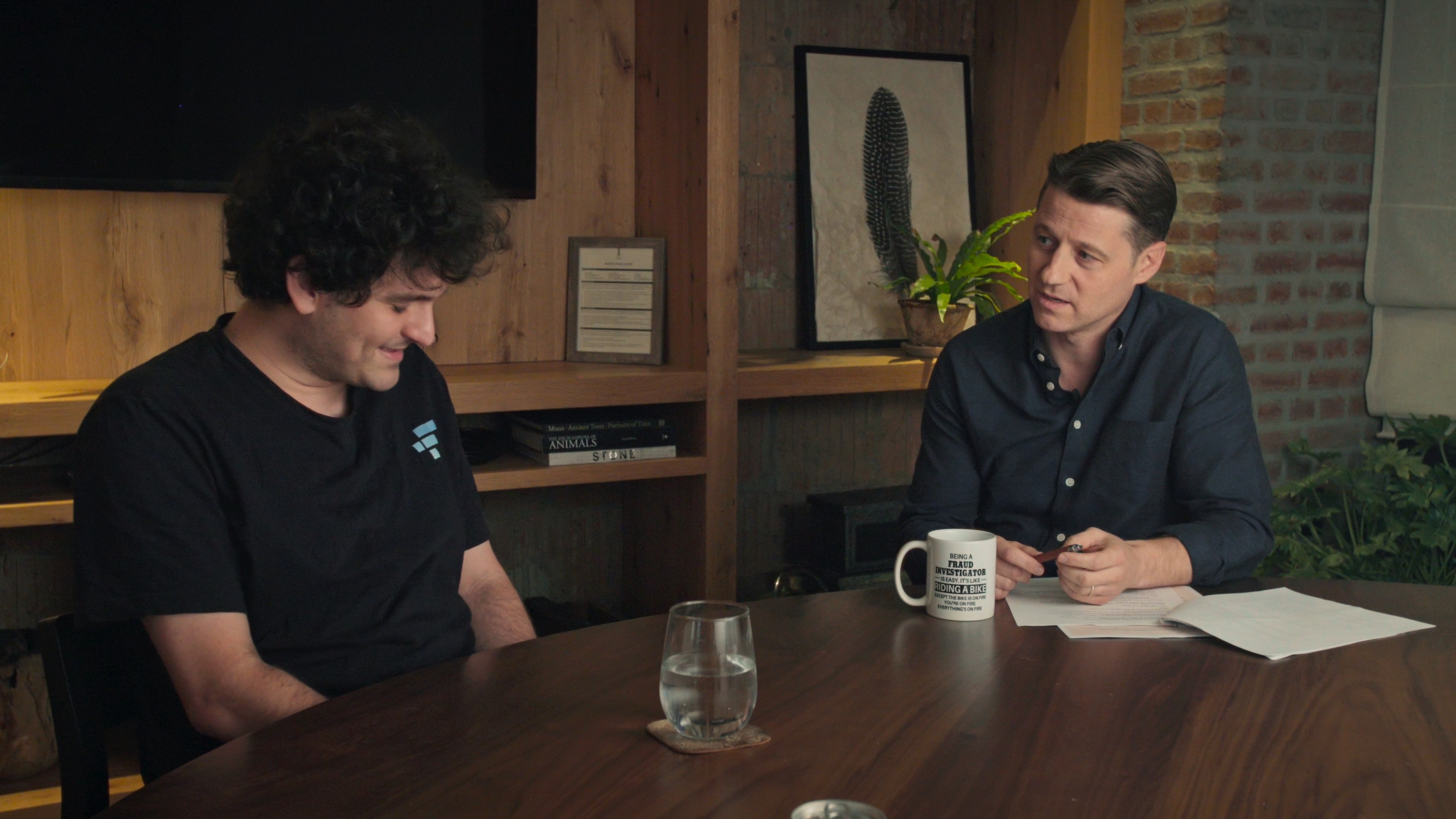 Ben McKenzie sitting at a table with Sam Bankman-Fried.