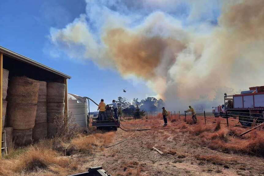 fire creeps close to shed as firefighters protect it