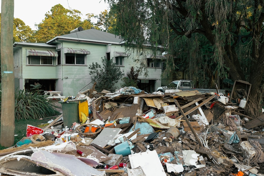 A muddy pile of destroyed home goods strewn on the median strip