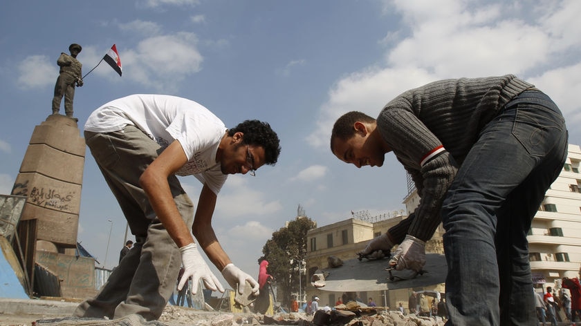 Men clean Tahrir Square in Cairo following the end of Mubarak's leadership.