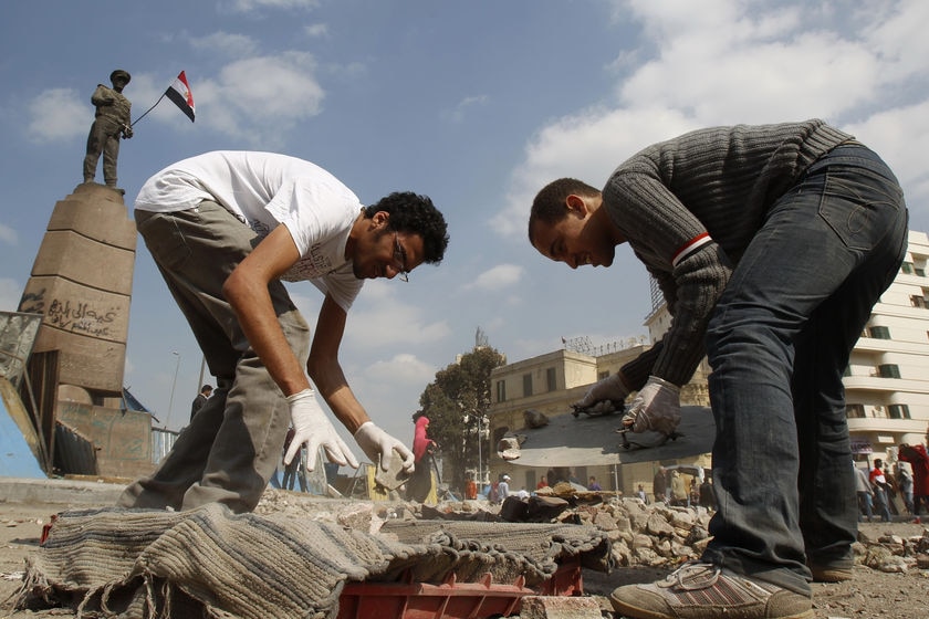 Men clean Tahrir Square in Cairo following the end of Mubarak's leadership.