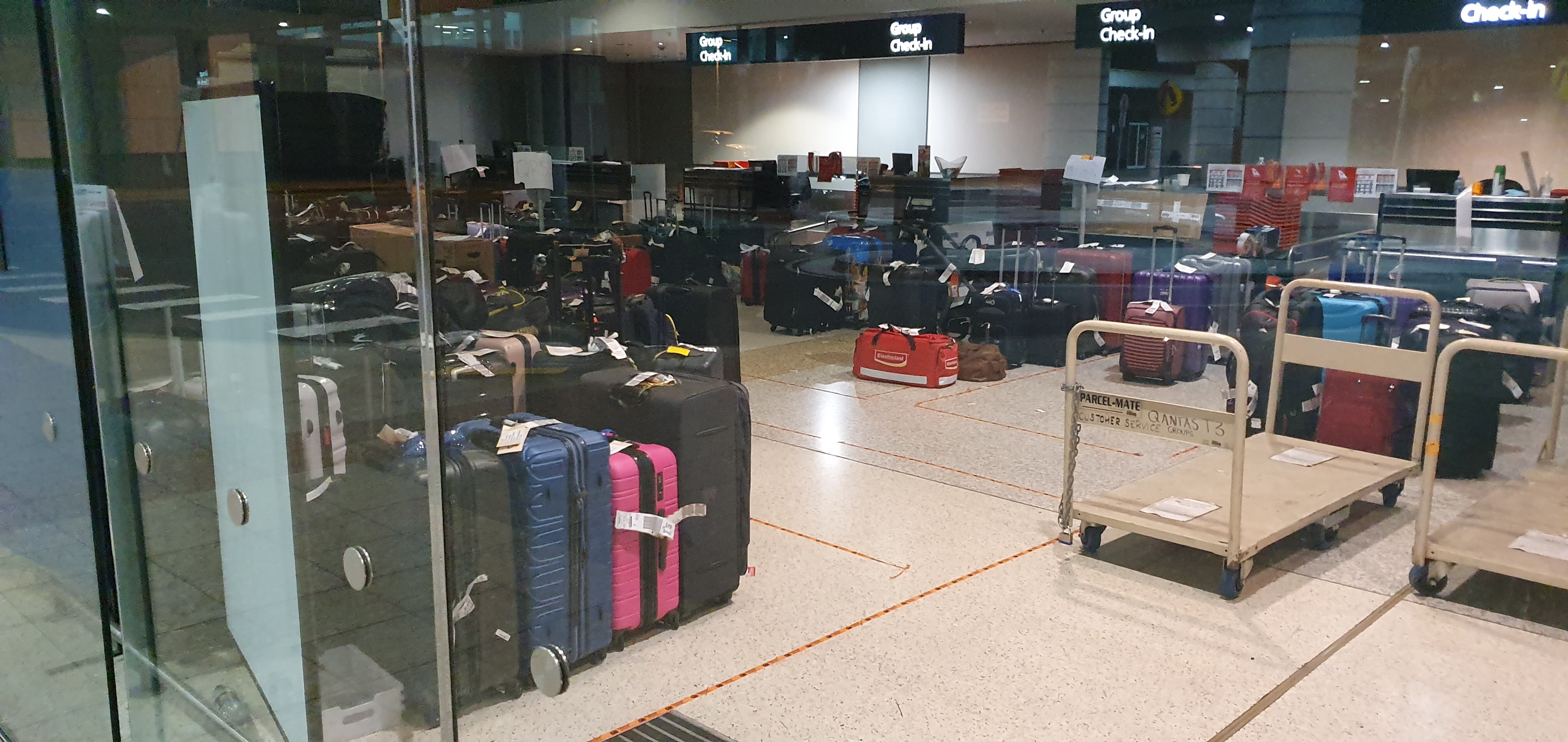 Suitcases and luggage sitting on the floor at the Qantas group check in area