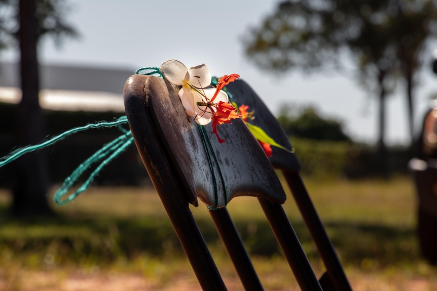 A flower is on the top of a chair and blows in the wind. 