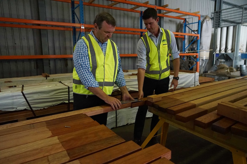 Lyle Hebb (left) and Dylan Hale inspect timber from Nhulunbuy