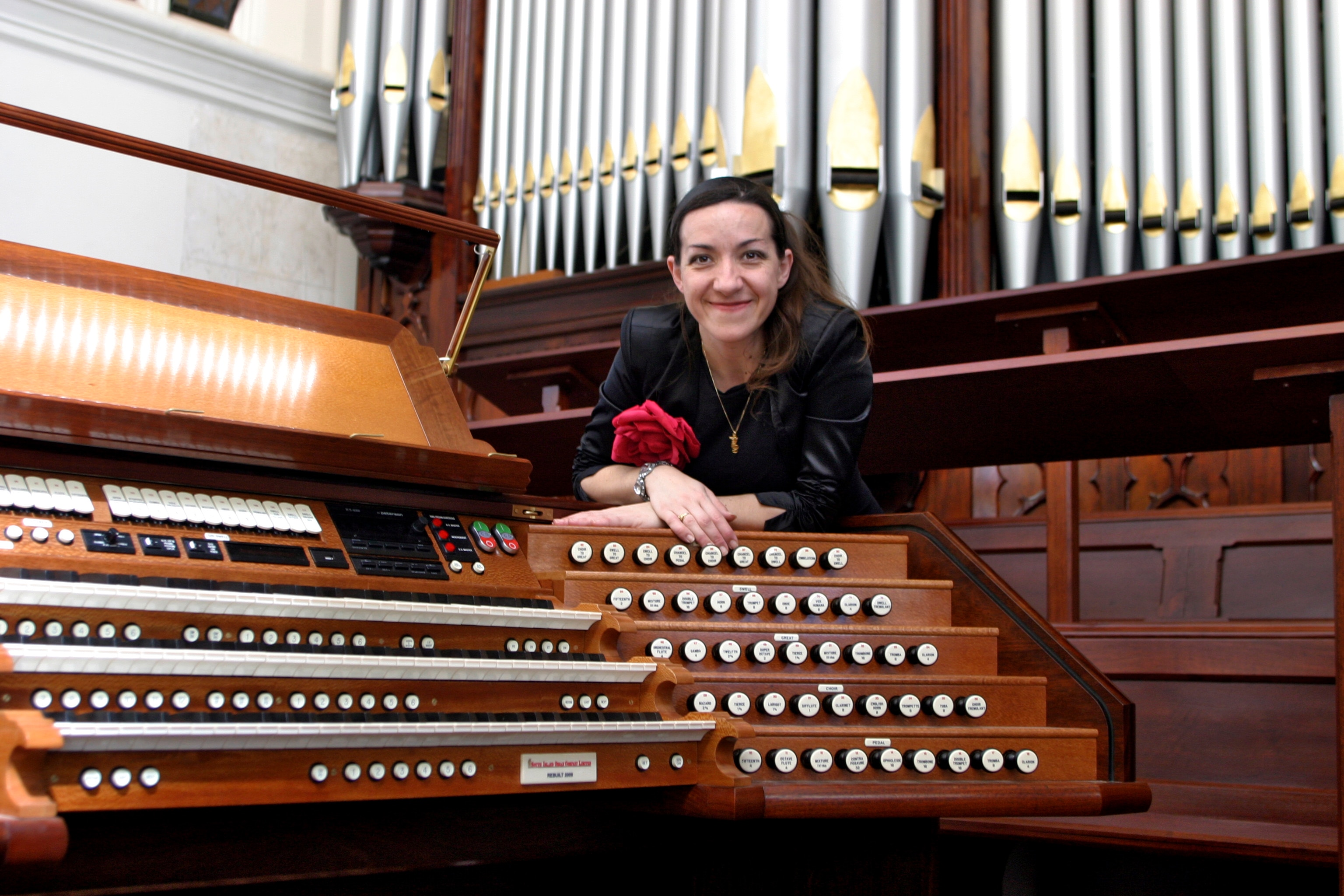 Jacinta is pictured behind an organ and wearing a rose on her black jacket