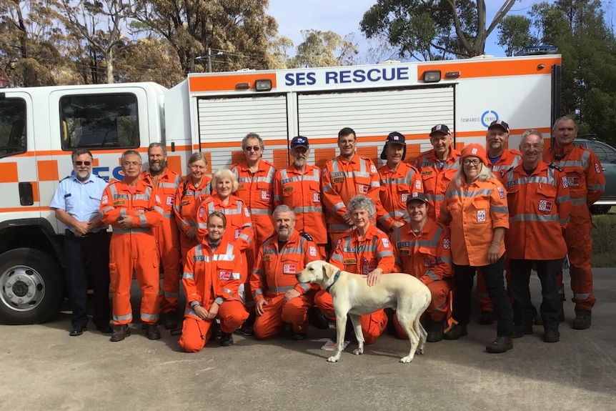 A group of people wearing orange SES uniforms in front of an SES rescue car