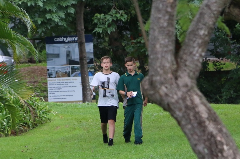 Josh and Daniel Penrose walking down the street with their letter box drops.