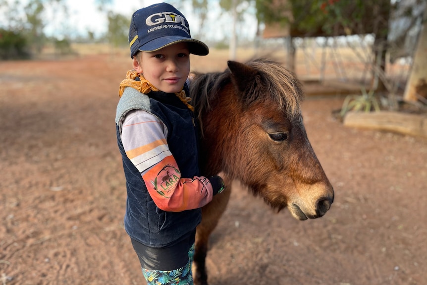 Jodie Muntelwit's son holding the neck of a small horse