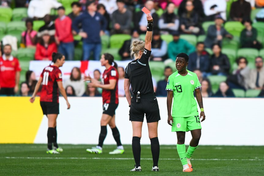 FIFA referee Lina Lehtovaara holds up a red card to Deborah Abiodun