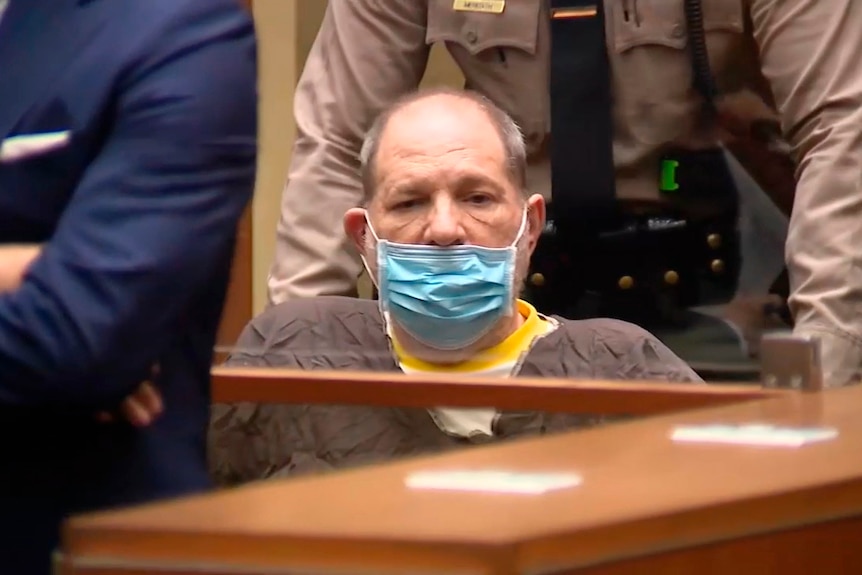 Harvey Weinstein wears a mask sitting in court