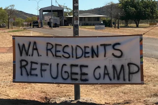A sign strung up on the side of the street says 'WA residents refugee camp'