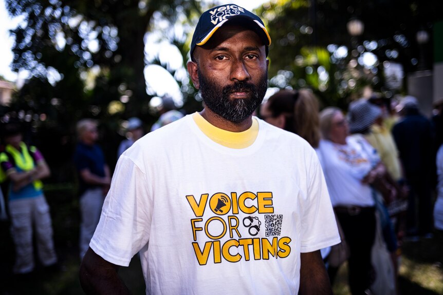 Dr Angelo Justus wearing a hat and shirt that reads 'voice for victims'
