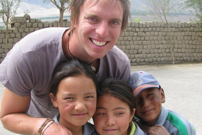 An Australian man stands with three children in india 