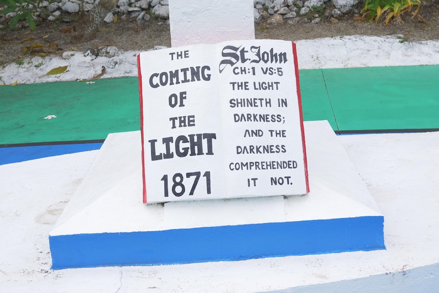 A close up of a monument which appears as a book and has written 'The coming of the Light' 1871.