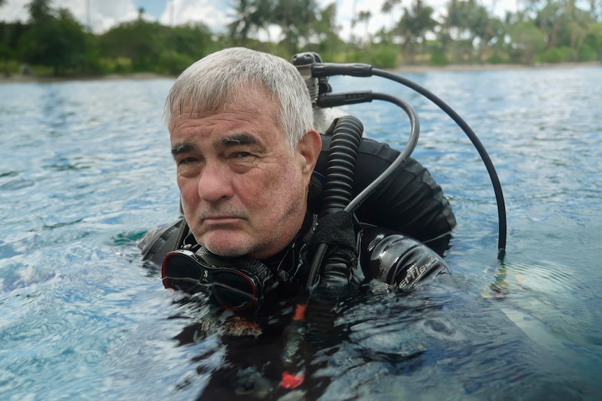 Neil Yates in scuba gear on the water's surface. 