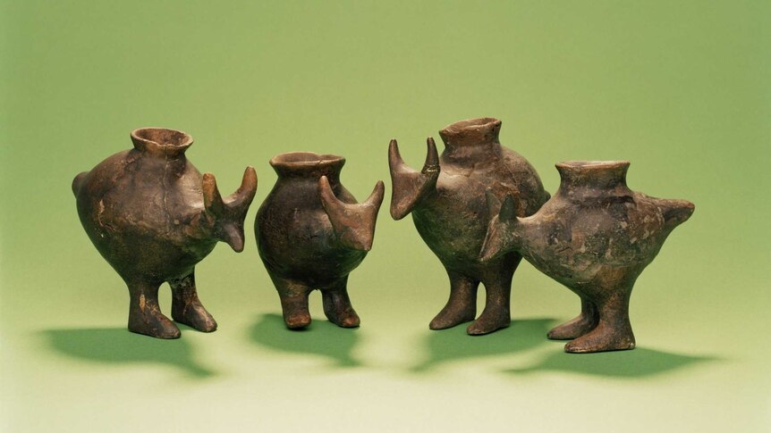 Four small, spouted vessels shaped like animals resembling a kangaroo