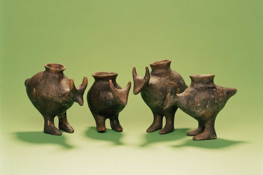 Four small, spouted vessels shaped like animals resembling a kangaroo