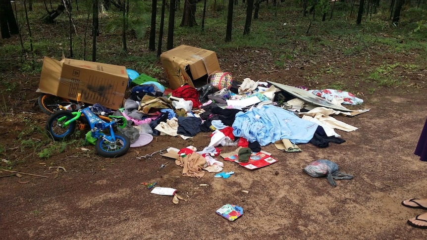 strew possessions and boxes in the bush