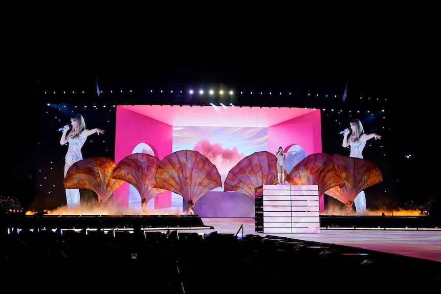 A popstar stands on stage ahead of an elaborate technical and visual performance with lights, videos and five giant fans.