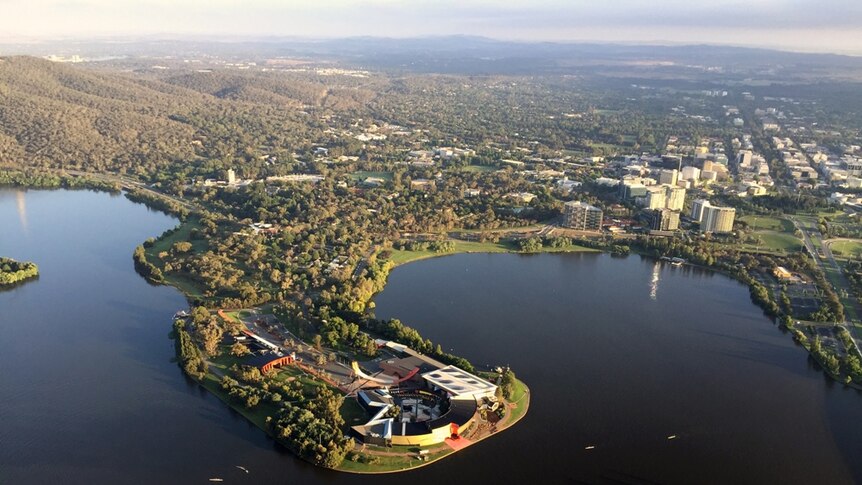 View from a hot air balloon above the national Museum of Australia and North Canberra in the background