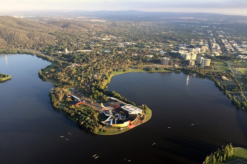 View from a hot air balloon above the national Museum of Australia and North Canberra in the background