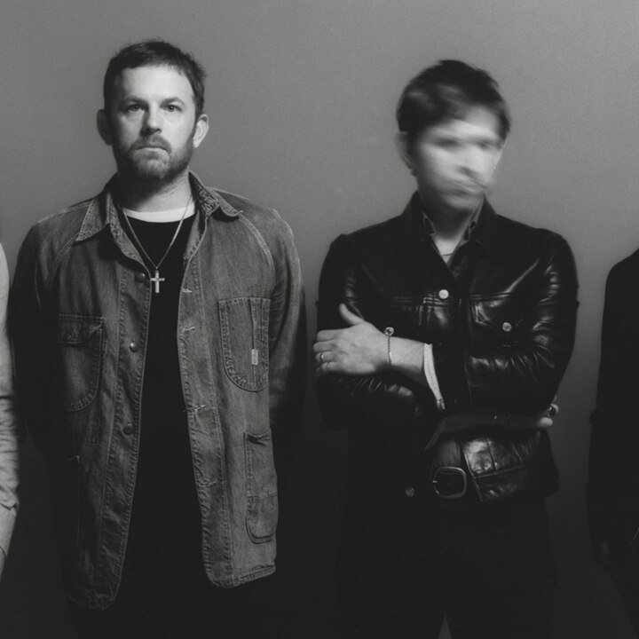 Black and white photo of the band Kings of Leon. Two faces are deliberately blurry.