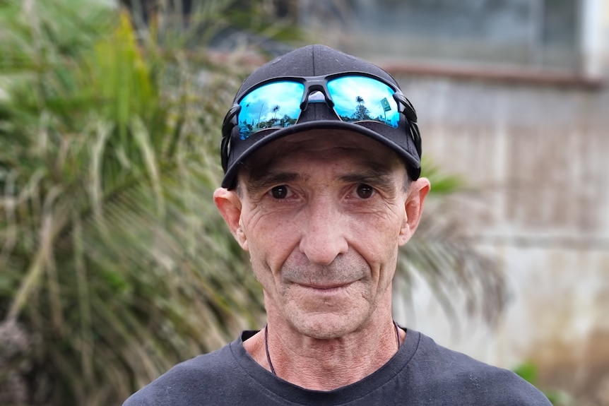 Dean Wilson standing infront of his house that is covered in thick black toxic sludge.