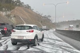 Cars among hail and black marks on a freeway