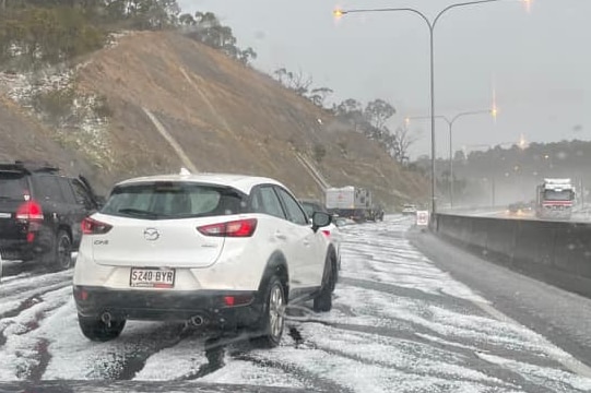 Cars among hail and black marks on a freeway