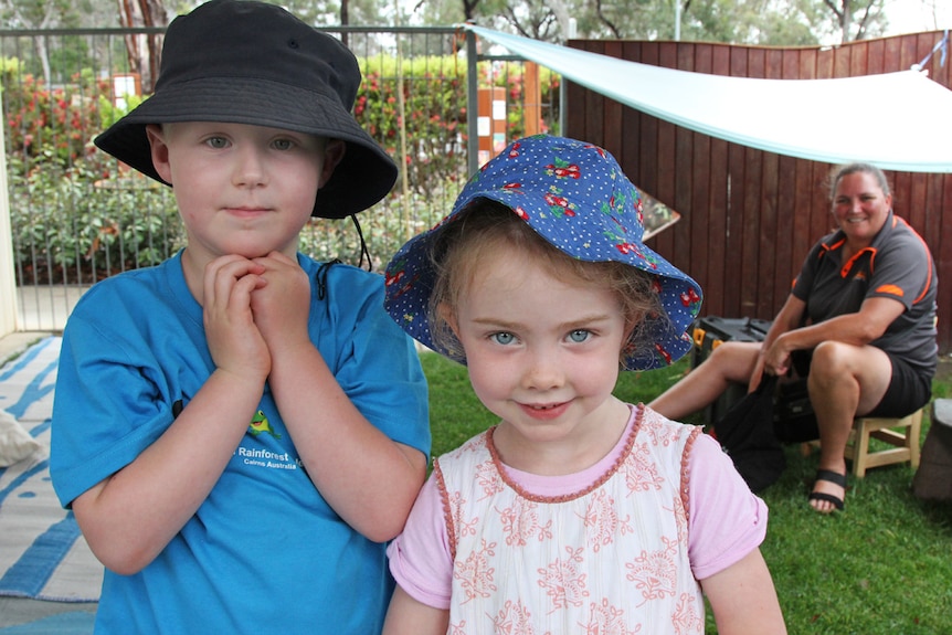 Two children smiling. Ms Jordan in the background.