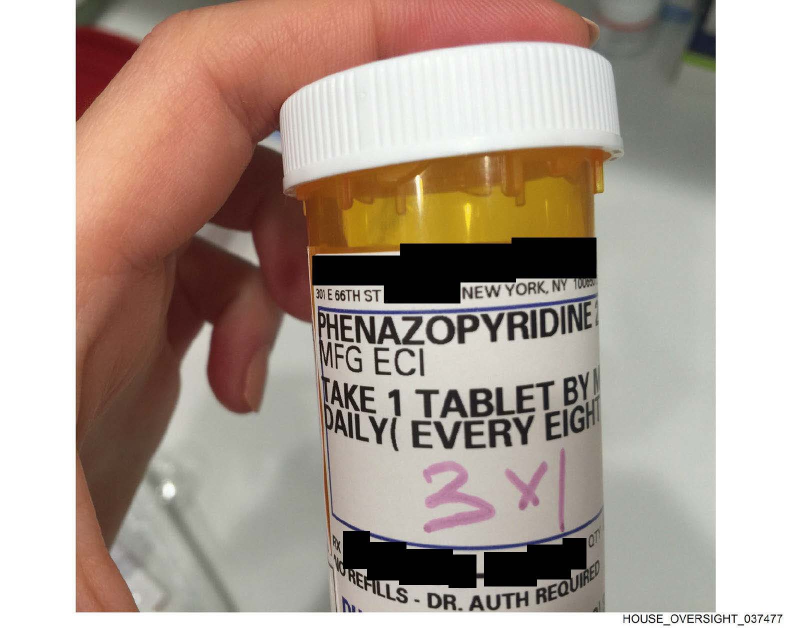 En la mano de una persona se sostiene un frasco de pastillas con instrucciones sobre cómo tomar fenazopiridina.