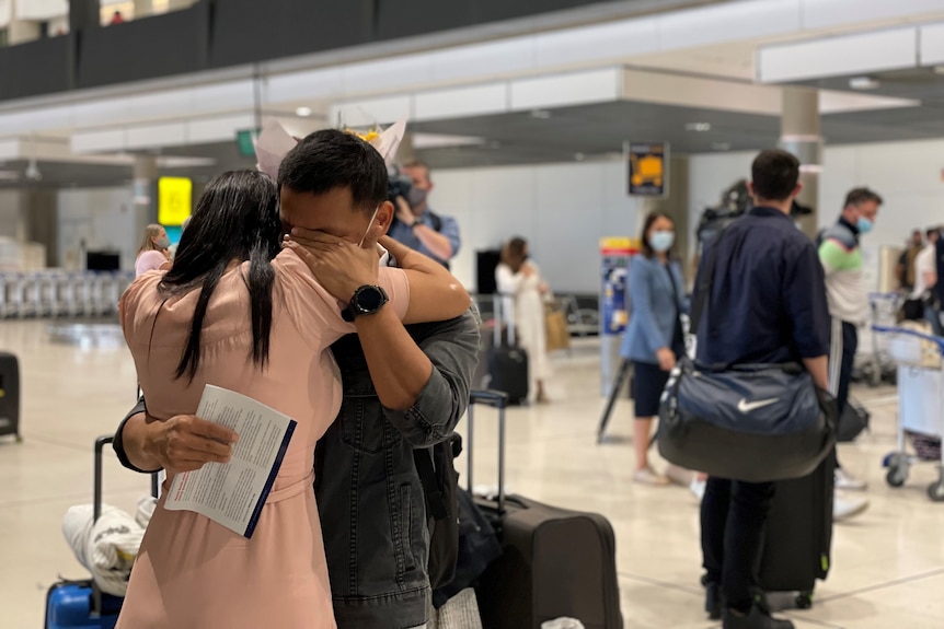 Bijay Thapa hugs his wife at Brisbane Airport.