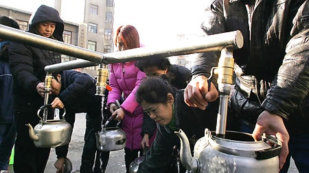 Harbin residents collect water from a tanker after a chemical plant explosion severely polluted one of the biggest Chinese rivers, causing water supplies to be cut for millions of people.