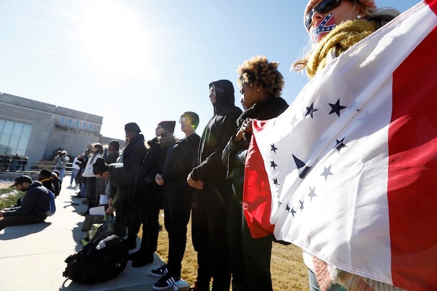 Protestors holding confederate battle flags line a pathway to the Civil Rights Museum