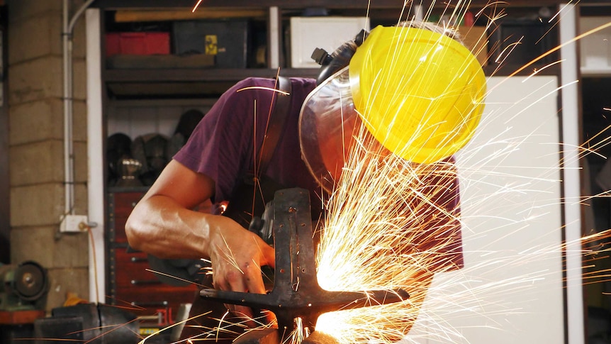 Armourer Joel Hunter wearing protecting equipment while he works with a propane torch.