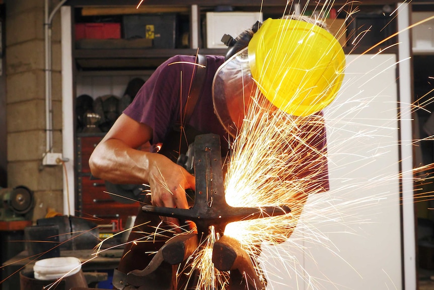 Armourer Joel Hunter wearing protecting equipment while he works with a propane torch.