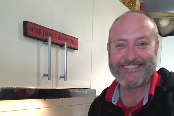 A man smiling in his kitchen