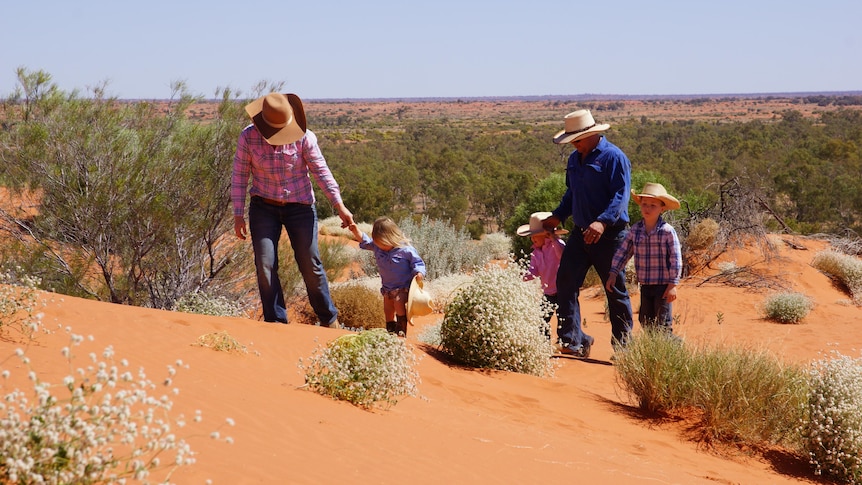 Photo of family walking up sand dune