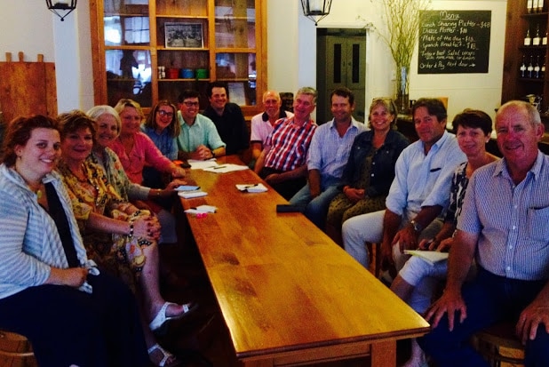 A group of volunteers sit around a long table inside a store.