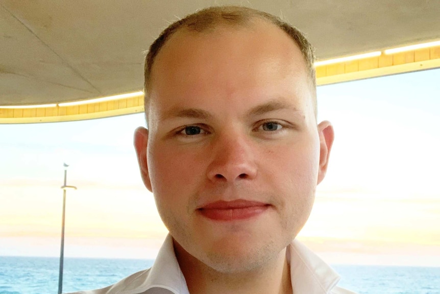 A close up of a man with very short hair on a boat