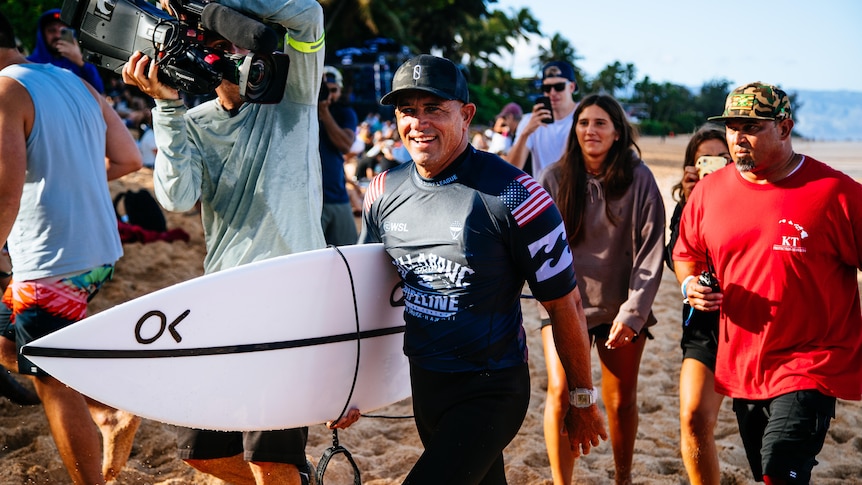 Kelly Slater celebrates after winning his hear at Billabong Pro Pipeline.