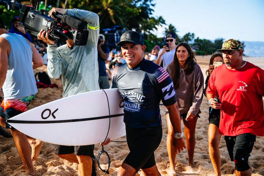 Kelly Slater celebrates after winning his hear at Billabong Pro Pipeline.