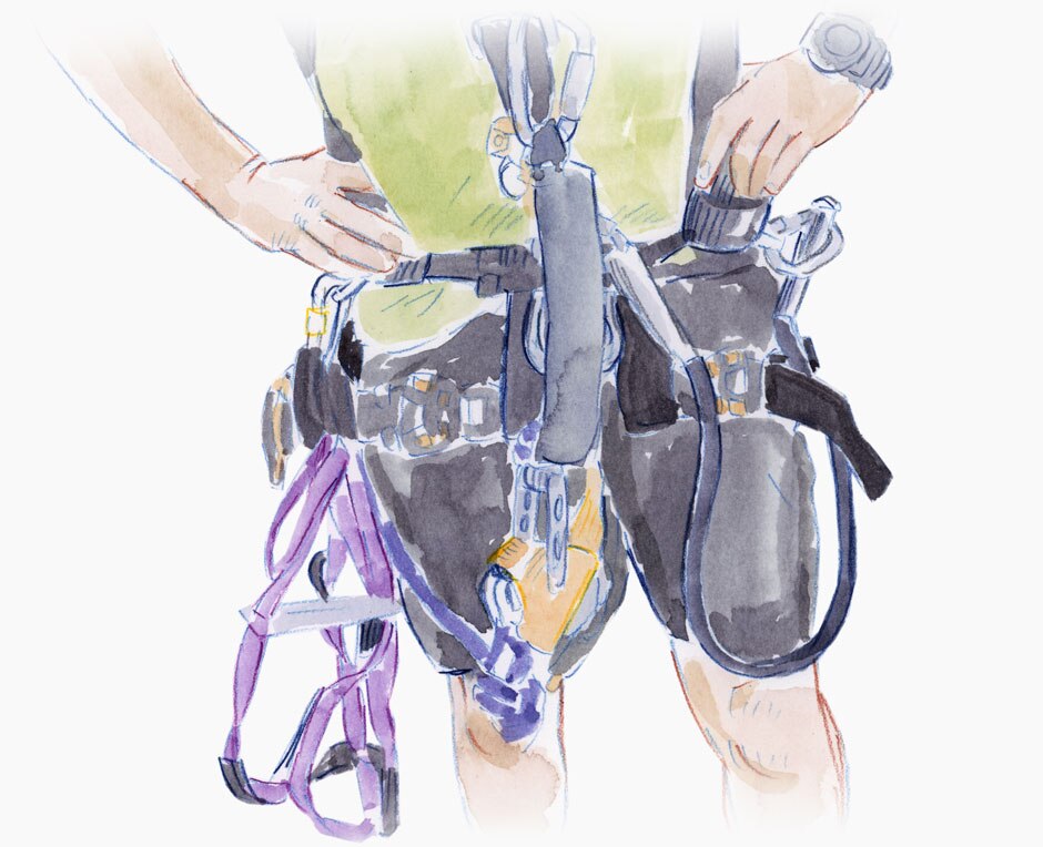 Torso of a man and the abseiling equipment he wears.