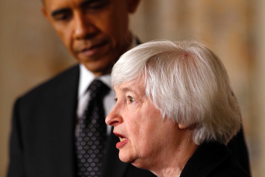 A woman with white hair talks in profile while US President Barack Obama listens in the background.