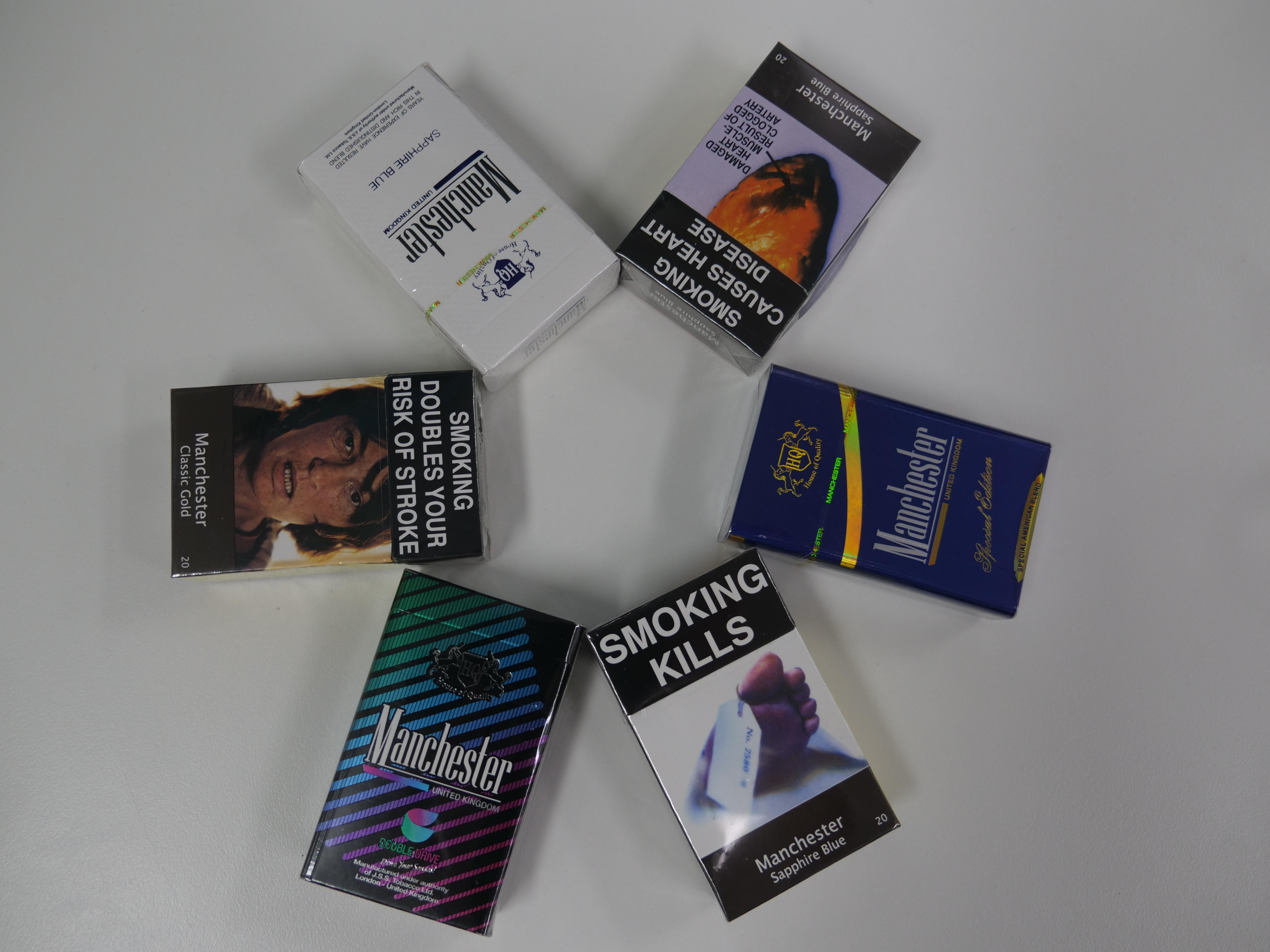 Six packs of cigarettes laid out. 
