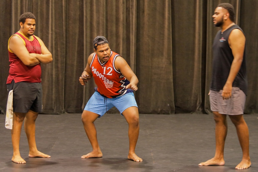 Three Torres Strait Islander men in a rehearsal room performing.