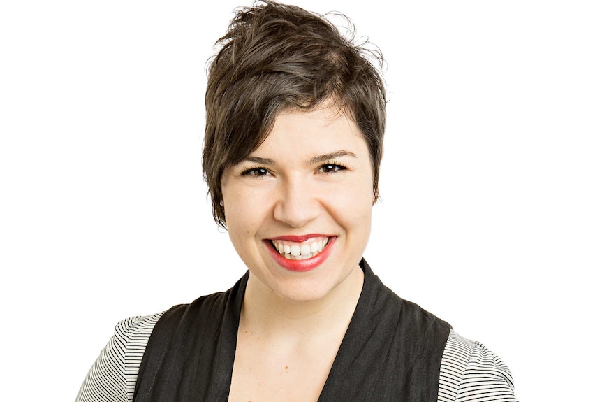 A smiling Dr Sansom-Daly stands in front of white background.