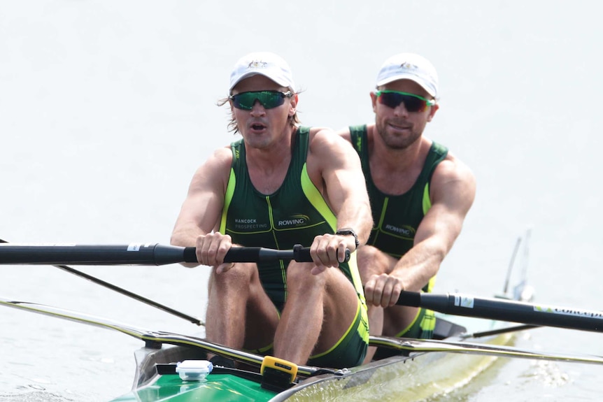 Two men, dressed in green and gold, rowing in the Men's Pair in 2019
