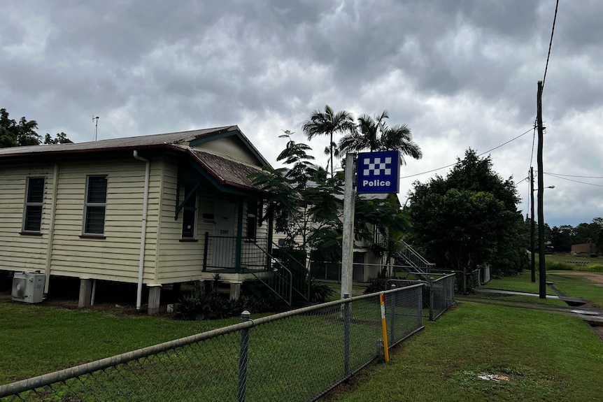 An old, small weatherboard house with a blue and white police sign out the front.