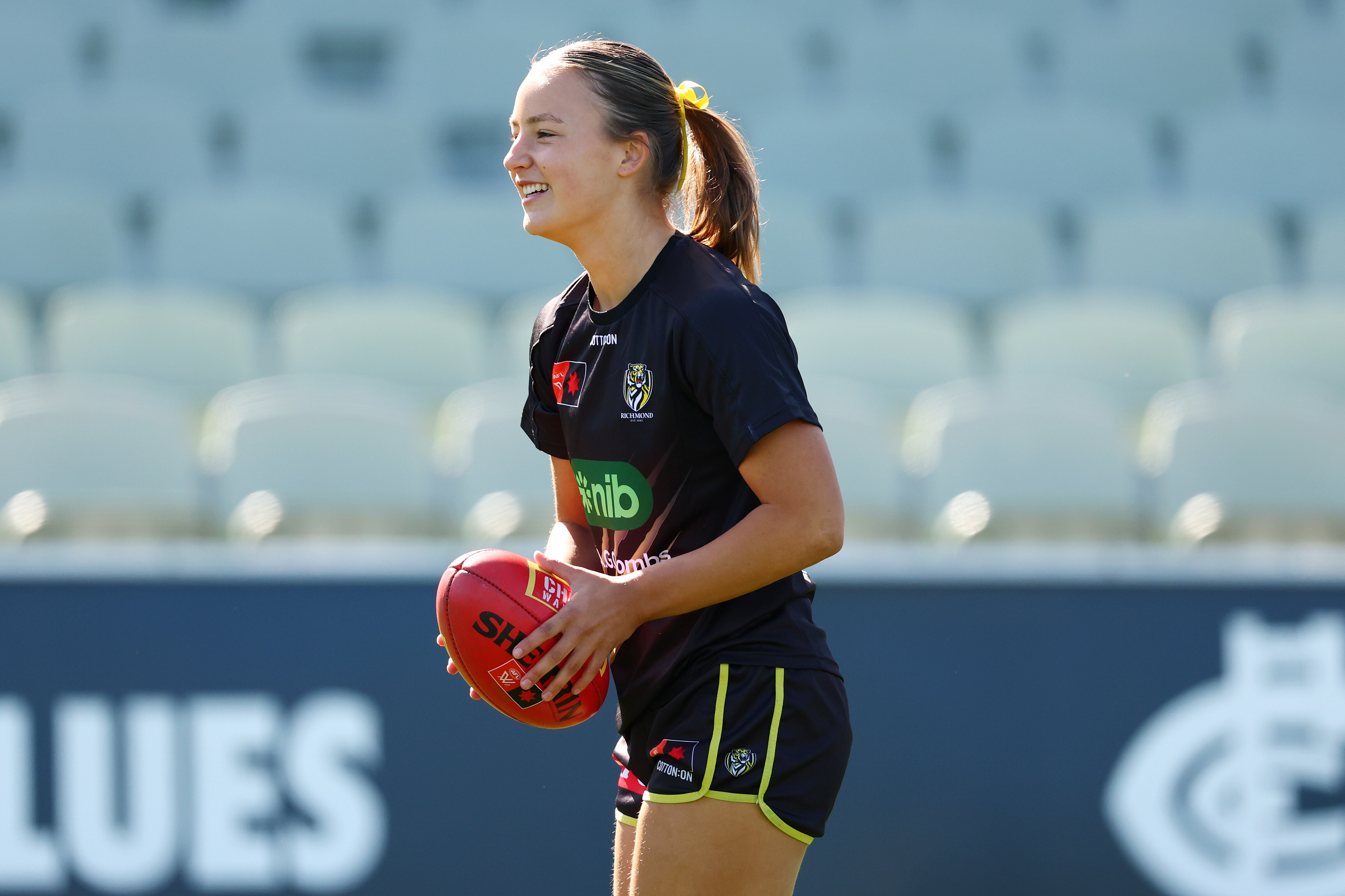 Lulu Beatty sorri enquanto segura um Sherrin.